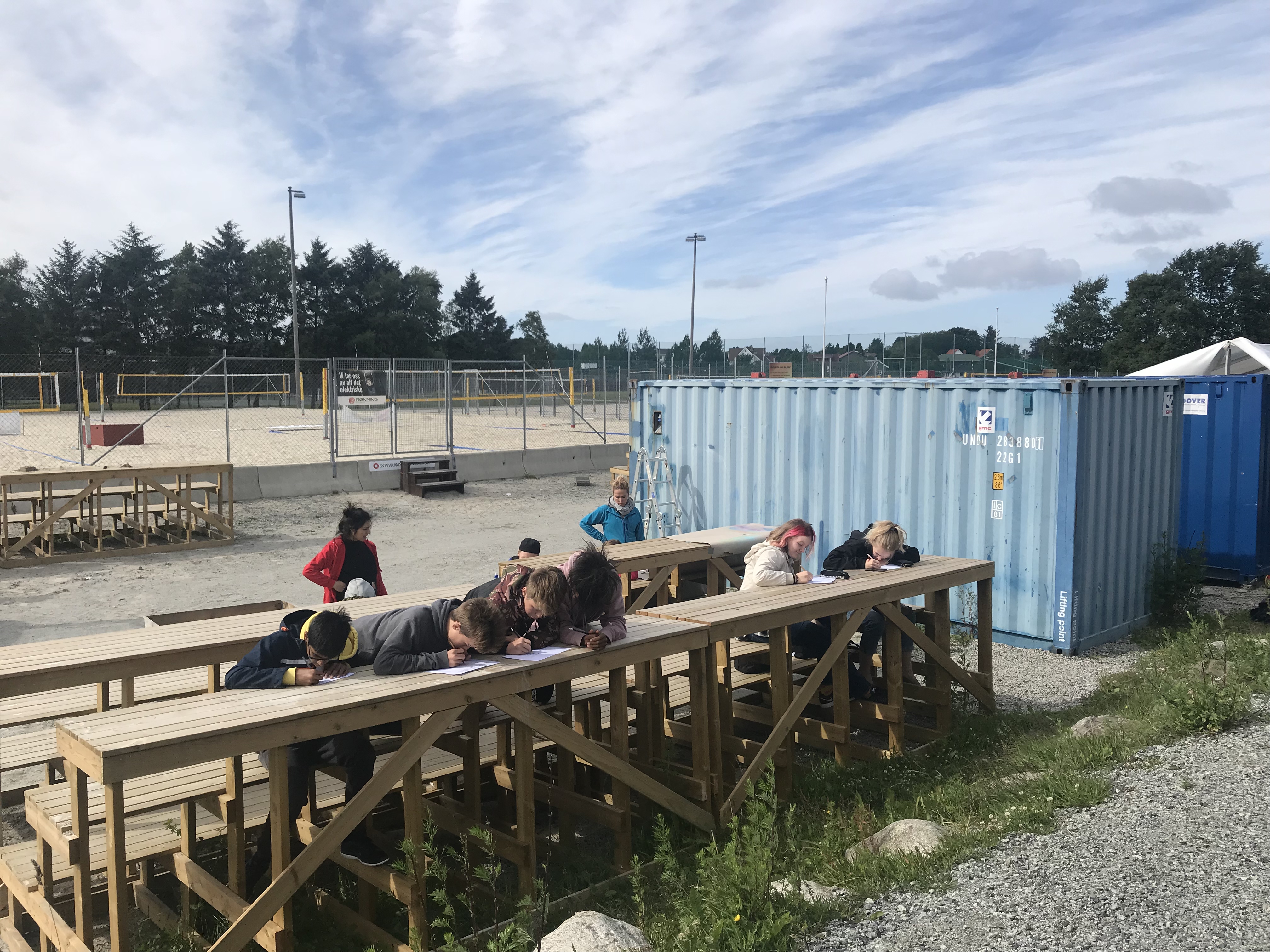 Ungdomsgjengen sitter på tribuneradene og tegner street art